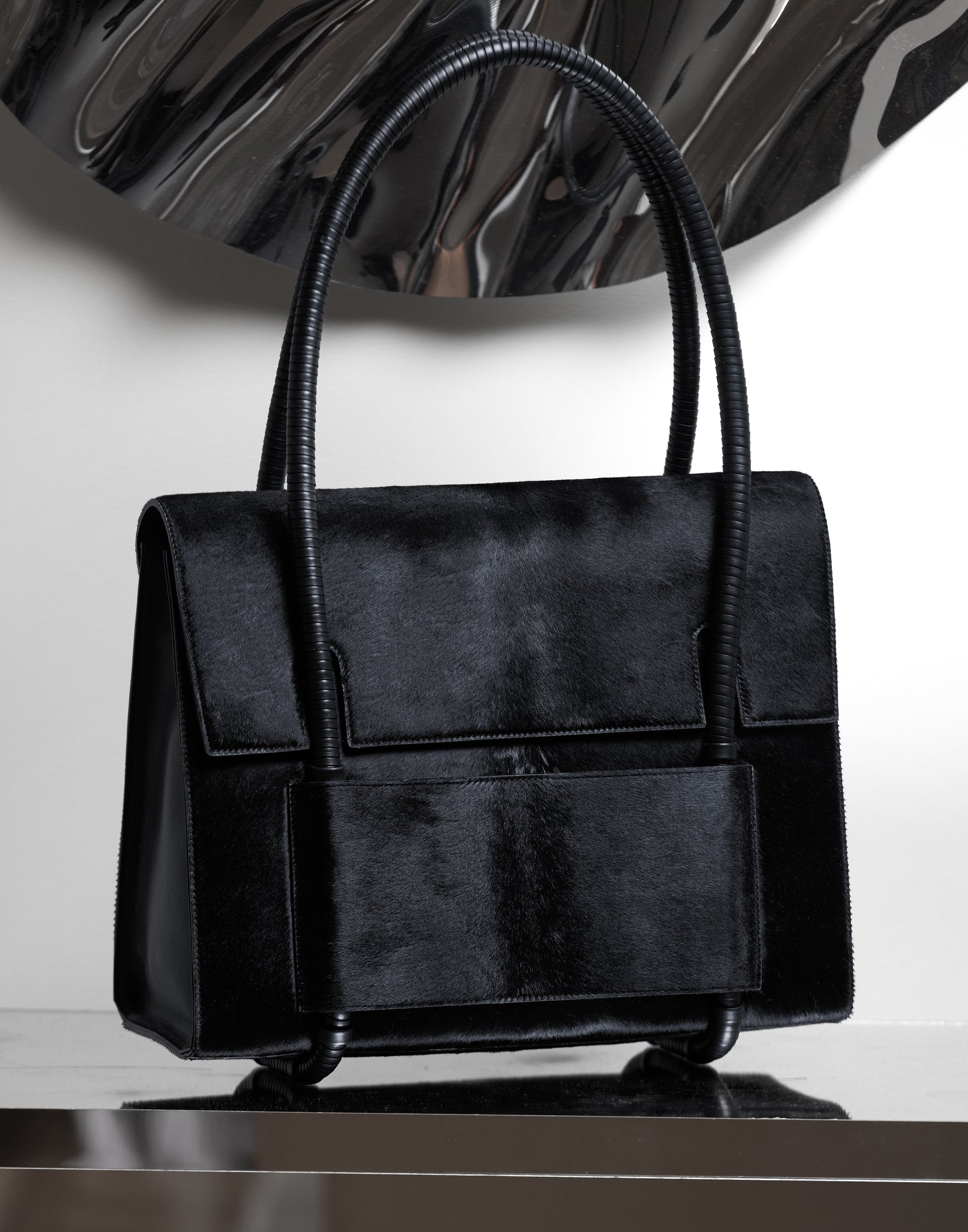 KUN HONG CHUA BAG CHUA MOTHER SATCHEL in BLACK FUZZ Black handbag on a reflective surface with a white background