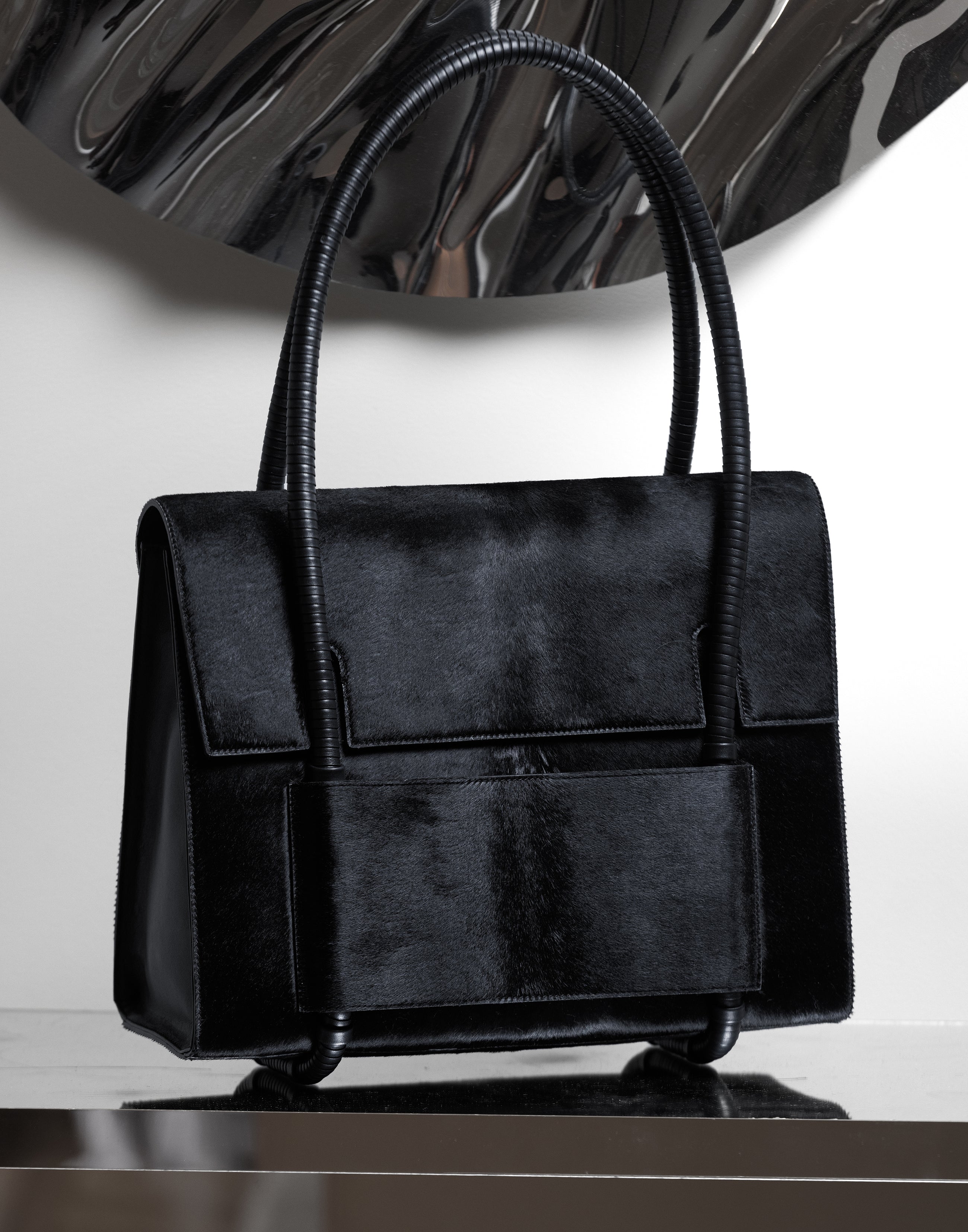 KUN HONG CHUA BAG CHUA MOTHER SATCHEL in BLACK FUZZ Black handbag on a reflective surface with a white background