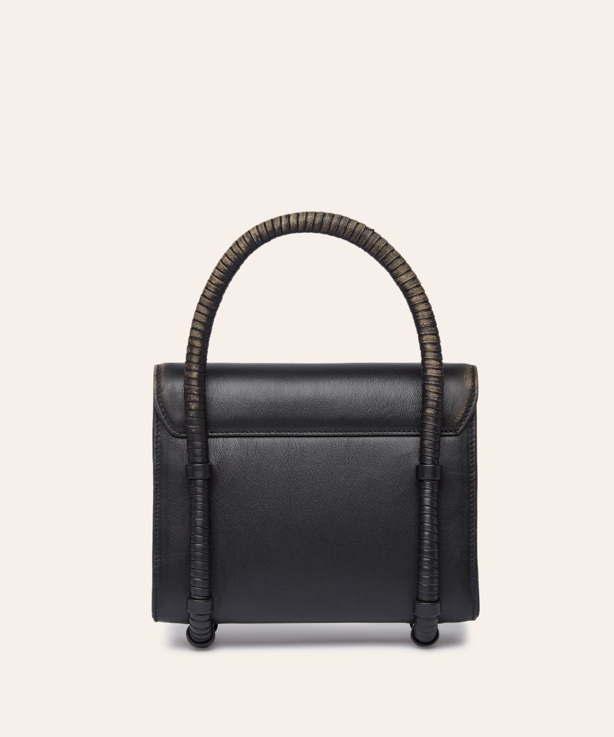 KUN HONG Black handbag with leather wrapped handle on a beige background