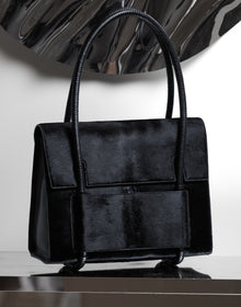 KUN HONG CHUA BAG CHUA MOTHER SATCHEL in BLACK FUZZ Black handbag on a reflective surface with a white background