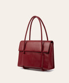KUN HONG CHUA MOTHER SATCHEL in HÓNG (2022) by Xiao Han and Kun Hong Red handbag on a light beige background
